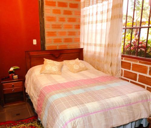 a bedroom with a bed and a brick wall at Hospedaje Valentina para ti y tu familia in Mera