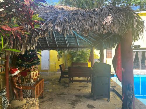 a patio with a thatch roof and a table at Coco Hotel and Hostel in Sosúa