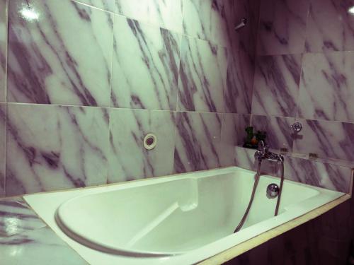 a white bath tub in a bathroom with marble walls at Hospedaje Valentina para ti y tu familia in Mera