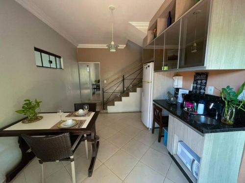a kitchen with a table and a counter top at Casa conforto e estilo in Palmas