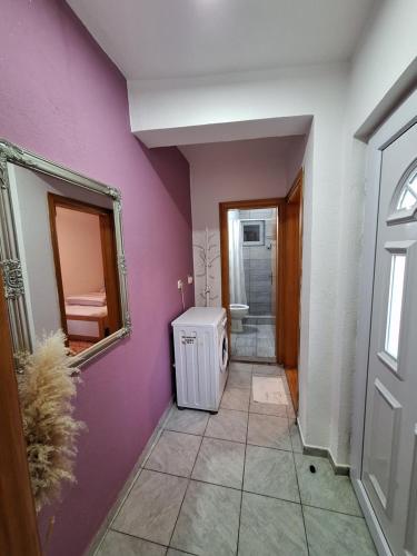 a hallway with a purple wall and a mirror at Hostel Miran Mostar in Mostar