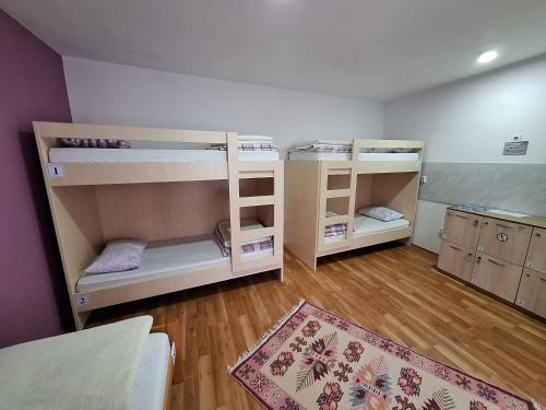 2 literas en una habitación con suelo de madera en Hostel Miran Mostar en Mostar