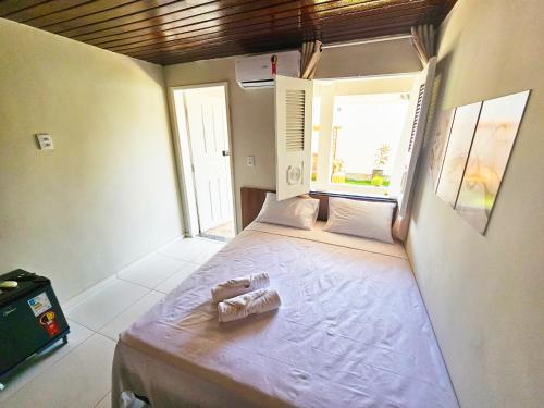 a small bed in a room with two windows at JF Studio Hotel in São Luís