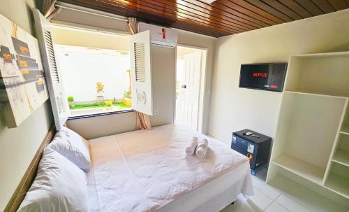 a small room with a bed and a window at JF Studio Hotel in São Luís