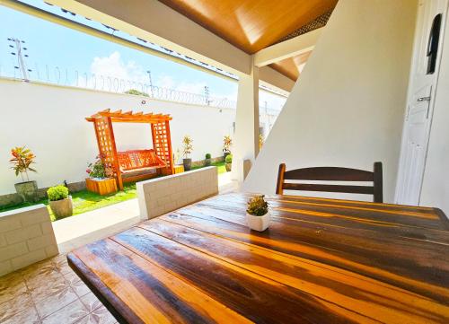 a large wooden table in a room with a large window at JF Studio Hotel in São Luís