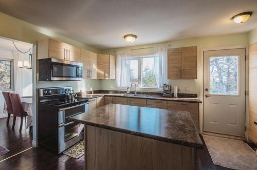 a kitchen with a large island in the middle at Yellowknife Downtown 50a ave Vacation Home in Yellowknife