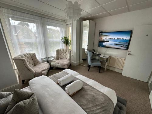 uma sala de estar com uma cama e uma televisão em 5 min from the beach ,parking in Guest House em Bournemouth