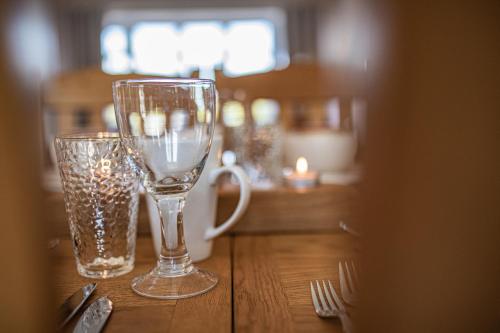 dos vasos sentados en una mesa de madera con tenedores en Styche View, beautiful 4 bedroom home available, en Market Drayton
