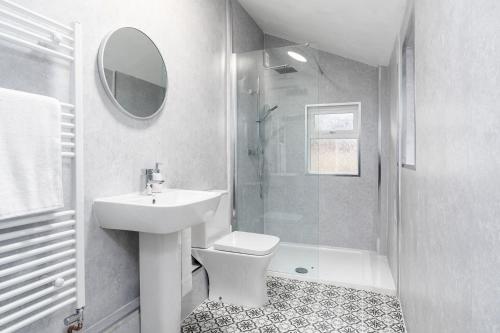 a white bathroom with a sink and a shower at The Cleveland Way, North Yorkshire in Loftus