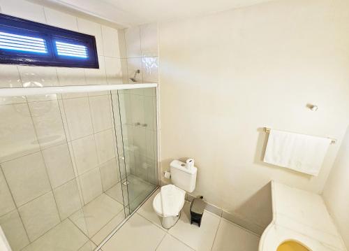 uma casa de banho com um WC e uma cabina de duche em vidro. em JF Studio Hotel em São Luís