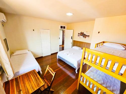 a room with two beds and a table and chairs at JF Studio Hotel in São Luís