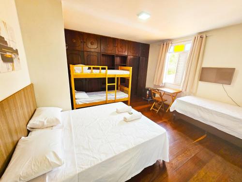 a bedroom with two beds and a bunk bed at JF Studio Hotel in São Luís