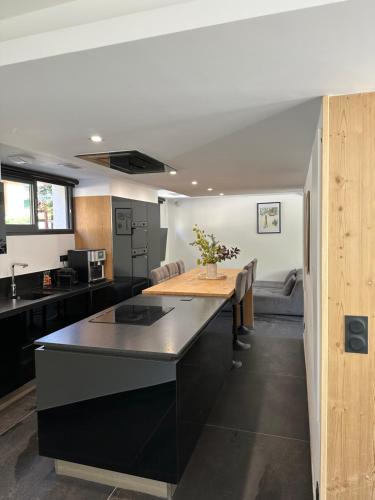 - une cuisine avec un îlot noir dans la chambre dans l'établissement Le Paradis Blanc luxueux Chalet Spa Serre-Chevalier, à La Salle Les Alpes