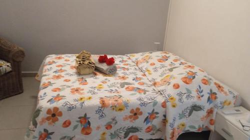 a bed with a blanket with flowers on it at Maison de vacances baca vue sur mer in Capesterre-de-Marie-Galante