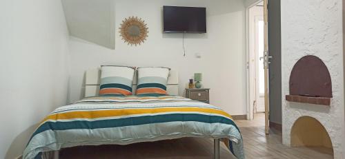 - une chambre avec un lit et une couverture rayée colorée dans l'établissement Appartement au rez-de-chaussée avec jardin privé, à Margny-lès-Compiègne