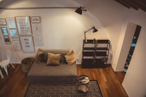uma sala de estar com um sofá e um candeeiro em Albinelli's Apartment - 10m from mercato Albinelli em Módena