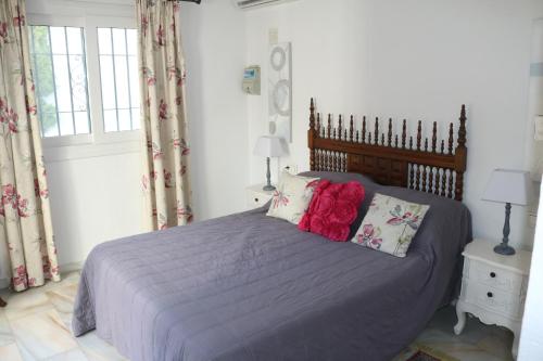 Schlafzimmer mit einem Bett mit lila Bettwäsche und Kissen in der Unterkunft Holiday Villa in Calahonda, near Marbella in Sitio de Calahonda