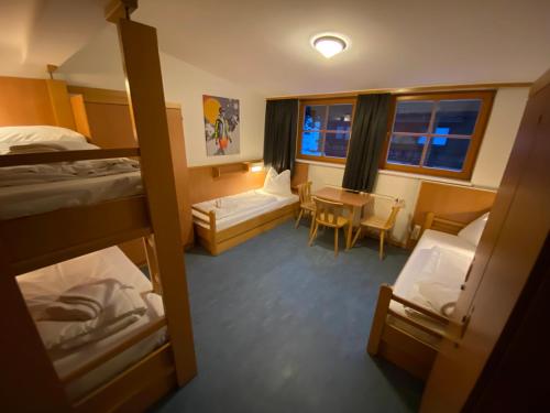 a room with bunk beds and a table and chairs at Twenty Seven Budget Hotel in Zell am See