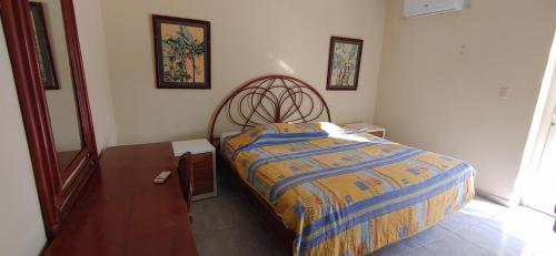 1 dormitorio con 1 cama con cabecero de madera en Residence Caribe, en Guayacanes