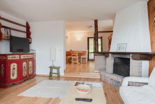 a living room with a couch and a fireplace at Casa Polsa, 280 m Piste in Prada