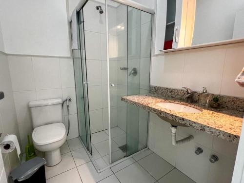 a bathroom with a shower and a toilet and a sink at Aguas do Santinho Residence - Praia do Santinho in Florianópolis