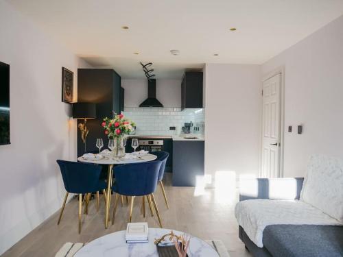 Stylish Retreat for Your Short Getaway في لندن: غرفة معيشة مع طاولة وكراسي زرقاء
