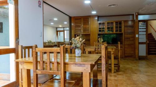 comedor con mesa de madera y sillas en Hostel Casa Roble en Mendoza