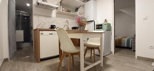 een keuken met een tafel en stoelen in een kamer bij Appartement au rez-de-chaussée avec jardin privé in Margny-lès-Compiègne