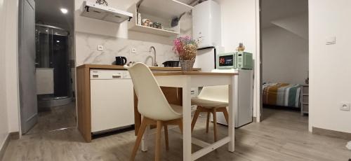 une cuisine avec une table et des chaises dans une pièce dans l'établissement Appartement au rez-de-chaussée avec jardin privé, à Margny-lès-Compiègne