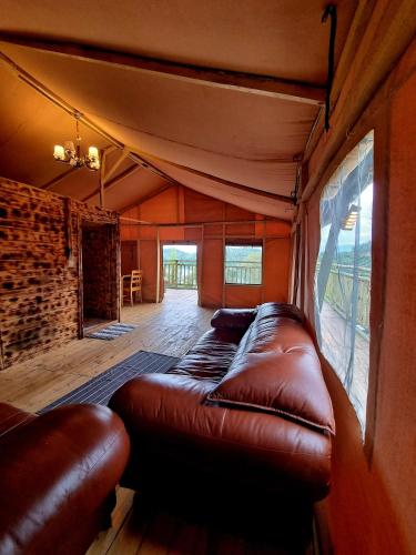 sala de estar con sofá de cuero en una habitación en Mzinga Retreat en Gitesi
