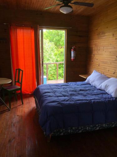 a bedroom with a bed and a large window at Las Alquimillas apart -a 70 metros de la playa- in Punta Del Diablo