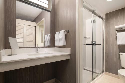 a bathroom with a sink and a mirror and a shower at Courtyard San Francisco Larkspur Landing/Marin County in Larkspur