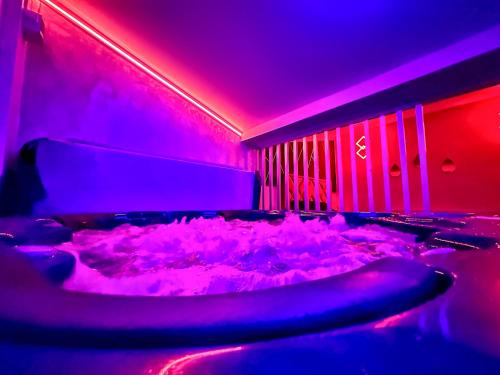 a room with a tub covered in snow with purple lights at Luxor - Jacuzzi&Cozy Apartments in Sibiu