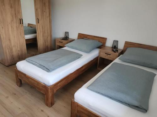 two twin beds in a room with wooden floors at Waldmohrer Hof in Waldmohr