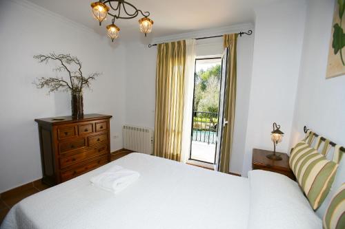 um quarto com uma cama branca e uma janela em Casa Rural Rafael Alberti em El Bosque