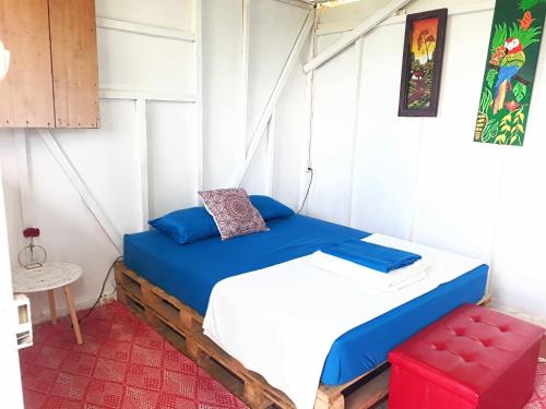 a small bedroom with a bed and a stool at Rustico Arenal B&B in Fortuna