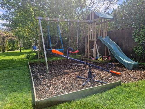 einen Spielplatz mit Rutsche und Schaukel in der Unterkunft NewForest-Spacious-4BDHolidayHome-Garden-Parking in Ringwood