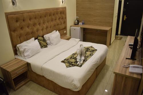 een hotelkamer met een bed met handdoeken erop bij Nour Hotel in Amman