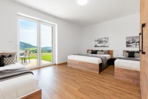 Un dormitorio con dos camas y una gran ventana. en #1 U Lanovky, en Červená Voda