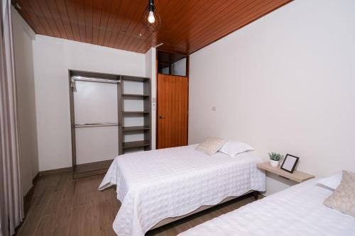 een slaapkamer met 2 bedden en witte lakens bij CASA MONA 3 - Apartamento en Tarapoto in Tarapoto
