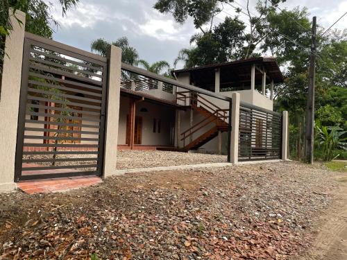 a house with a wooden gate and a staircase at Vila Guaraú in Peruíbe