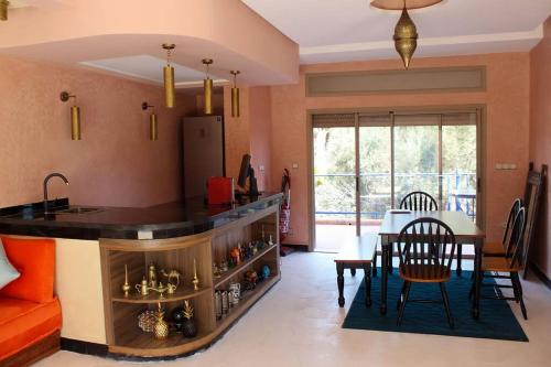 eine Küche und ein Esszimmer mit einem Tisch und einer Theke in der Unterkunft Villa pied lac, jet ski, quad, piscine, internet in Marrakesch
