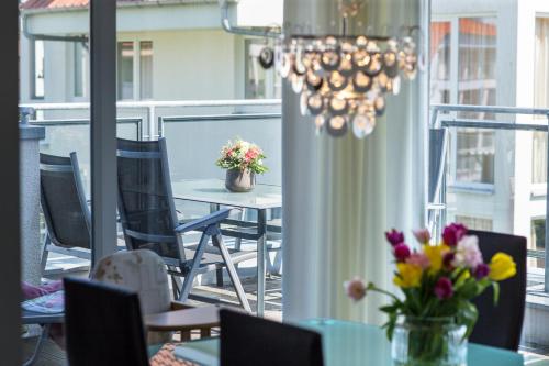 un balcone con tavolo, sedie e lampadario pendente di Penthouse "Ostsee-Himmelreich" Großenbrode a Grossenbrode