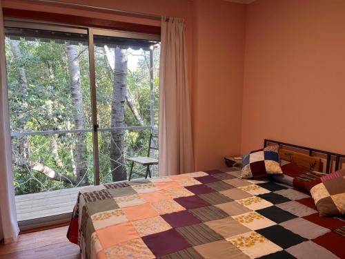 ein Schlafzimmer mit einem Bett und einem großen Fenster in der Unterkunft Techos Amarillos aparthotel in Fomento