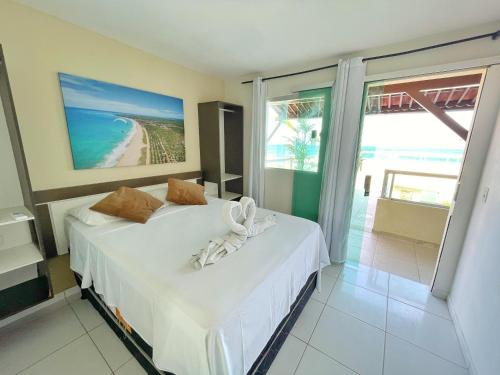 a bedroom with a bed with a view of the beach at Pousada Ondas do Mar in Porto De Galinhas