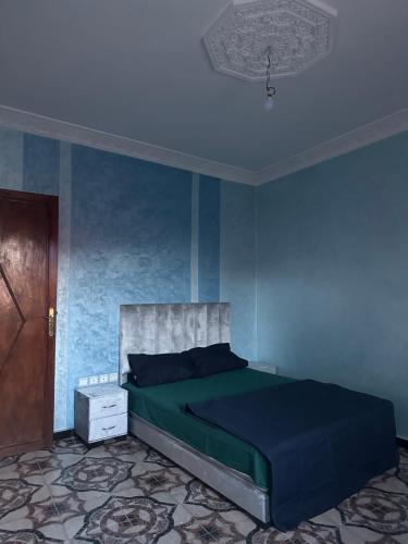 a bedroom with a bed and a blue wall at Stylish Moroccan appartement in Marrakesh