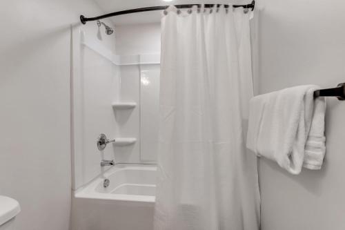 a white bathroom with a shower curtain and a tub at Newly Built Modern Park City Getaway l Zen by Stay in Park City