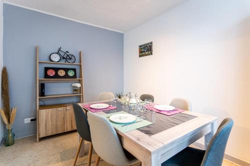 a dining room with a wooden table and chairs at 034- Tropisme, Appart 2 chambres, Clim, Wifi, Parking in Montpellier