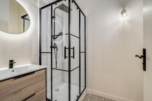 La salle de bains est pourvue d'une douche et d'un lavabo. dans l'établissement Le poudré Cours Fauriel magnifique appartement, à Saint-Étienne