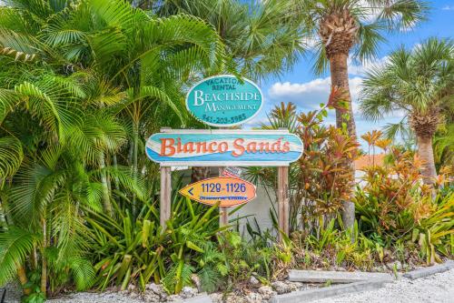 a sign for a bicheno sands resort with palm trees at Bianco Sands By Beachside Management in Siesta Key